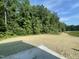 Cleared property with a gravel driveway and lush forest surroundings, ready for construction at 507 Olivia Crossing Ct # 20, Four Oaks, NC 27524