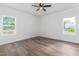 This bedroom features wood floors, a ceiling fan and large windows providing ample natural light at 620 Gilmer St, Burlington, NC 27217