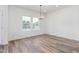Bright dining room with wood-look flooring, modern chandelier, and large windows at 620 Gilmer St, Burlington, NC 27217