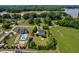 Aerial view of a blue house surrounded by lush trees, a well-kept lawn, and a neighboring pool at 6489 Waters Edge Dr, Rocky Mount, NC 27803