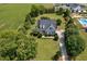 Aerial view shows the home with a spacious yard, lush greenery, and a swimming pool in the distance at 6489 Waters Edge Dr, Rocky Mount, NC 27803