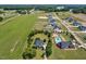 Aerial view of a charming two-story home with manicured lawn and a neighborhood pool in the distance at 6489 Waters Edge Dr, Rocky Mount, NC 27803
