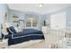 Light blue bedroom with a navy quilt-covered bed, decorative shelving and white wicker furniture at 6489 Waters Edge Dr, Rocky Mount, NC 27803