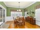 Green-walled dining room with hardwood floors, abundant natural light, and a decorative buffet at 6489 Waters Edge Dr, Rocky Mount, NC 27803