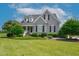 Charming two-story home featuring a well-manicured lawn, tasteful landscaping, and classic architectural details at 6489 Waters Edge Dr, Rocky Mount, NC 27803