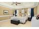 Spacious main bedroom featuring a four-poster bed, tan walls, and a window with wood blinds at 6489 Waters Edge Dr, Rocky Mount, NC 27803