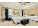 Bright main bedroom features a four-poster bed, tray ceiling, and large windows with blue drapes at 6489 Waters Edge Dr, Rocky Mount, NC 27803