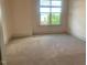 Carpeted bedroom featuring a large window and neutral colored walls at 700 Finsbury St # 304, Durham, NC 27703