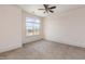 Neutral bedroom with a large window providing ample natural light, carpet flooring and a ceiling fan at 700 Finsbury St # 304, Durham, NC 27703