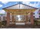 A view of the street framed by a brick gazebo at 700 Finsbury St # 304, Durham, NC 27703