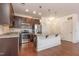 Modern kitchen with dark wood cabinets, stainless steel appliances, and a granite topped island at 700 Finsbury St # 304, Durham, NC 27703
