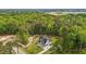 Aerial view of home featuring a well-manicured lawn, extended driveway, and green forest background at 80 Carnation Rd, Youngsville, NC 27596