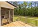 View of the wooden back deck and yard featuring a screened door that looks into the home's interior at 80 Carnation Rd, Youngsville, NC 27596