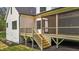 Angled view of the back porch with screens and wooden deck with stairs leading to the yard at 80 Carnation Rd, Youngsville, NC 27596