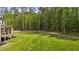 Large green backyard view with lush green trees surrounding the property and home's back exterior at 80 Carnation Rd, Youngsville, NC 27596