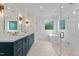 Beautiful bathroom features dual sinks, teal cabinets with gold hardware, a freestanding tub, and a glass shower at 80 Carnation Rd, Youngsville, NC 27596