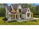 Angle view of a two-story home featuring a stylish combination of white, wood, and dark accents at 80 Carnation Rd, Youngsville, NC 27596