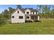 Wide view of back exterior with black roof and window frames, a covered porch and a green backyard at 80 Carnation Rd, Youngsville, NC 27596