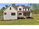 Back exterior view of home with black window frames, white walls, porch, stairs, and green backyard at 80 Carnation Rd, Youngsville, NC 27596