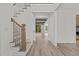 Bright foyer features hardwood floors, staircase, and a view into the living area with beamed ceiling at 80 Carnation Rd, Youngsville, NC 27596
