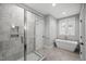 Modern bathroom featuring a standalone tub, marble tiled shower, and window for natural light at 917 S Blount St, Raleigh, NC 27601