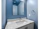 Bathroom sink with blue walls, marble countertop, and mirror at 917 S Blount St, Raleigh, NC 27601