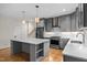 Modern kitchen boasts gray cabinets, stainless steel appliances, island, and hardwood floors at 917 S Blount St, Raleigh, NC 27601
