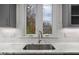 Kitchen sink with white countertop and subway tile backsplash, looking out to the backyard at 917 S Blount St, Raleigh, NC 27601