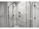 Walk-in shower featuring marble tiling, a rainfall shower head, and built-in shower caddy at 917 S Blount St, Raleigh, NC 27601