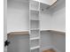 Bright, walk-in closet featuring shelving and wooden railing, and a dark door handle at 917 S Blount St, Raleigh, NC 27601