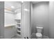 Walk-in closet with shelving and railing on the right side, and a toilet on the right side at 917 S Blount St, Raleigh, NC 27601