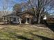 Cozy brick home featuring a screened-in porch, nestled on a sun-dappled lot with mature trees at 922 N White St, Wake Forest, NC 27587
