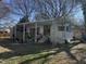Mobile home with covered porch, set in a sunny, tree-filled yard ready for a modernizing refresh at 922 N White St, Wake Forest, NC 27587