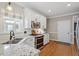 Bright kitchen featuring stainless steel appliances, white cabinets, and granite countertops at 110 White Bloom Ln, Cary, NC 27519