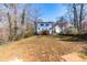 Back view of a house with a backyard featuring grass and some trees on a sunny day at 1211 N Guthrie Ave, Durham, NC 27703