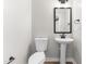 Modern half bathroom featuring a pedestal sink, updated fixtures, and a sleek mirror, offering a stylish touch at 1211 N Guthrie Ave, Durham, NC 27703
