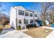 Lovely white townhouse with black framed windows, a front porch, and a driveway to the left at 1211 N Guthrie Ave, Durham, NC 27703