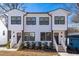 Charming townhouse featuring a white exterior, black window frames, and inviting front steps at 1211 N Guthrie Ave, Durham, NC 27703