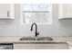Close-up of the kitchen sink and granite countertops against the backdrop of white hexagon tile at 1211 N Guthrie Ave, Durham, NC 27703