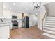 Open-concept kitchen featuring modern appliances, granite countertops, and access to the staircase and hallway at 1211 N Guthrie Ave, Durham, NC 27703
