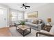 Cozy living room with a grey sofa, wood floors, and large windows providing natural light at 1211 N Guthrie Ave, Durham, NC 27703