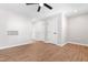 Spacious room with wood flooring, white walls, ceiling fan, and multiple doorways at 1211 N Guthrie Ave, Durham, NC 27703