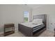 Comfortable bedroom featuring a padded bed frame, neutral walls, a side table, and carpeted floors with a window at 1425 Beaver Tan Ct, Wake Forest, NC 27587