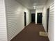 Hallway with neutral-colored carpet leading to apartment doors at 1647 Kenmore Dr, Clayton, NC 27520