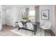 Bright dining room features a modern table and chairs, accent rug, and large window with natural light at 1748 Post Oak Dr, Haw River, NC 27258