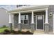 Inviting front porch with white columns and a stylish gray front door at 1748 Post Oak Dr, Haw River, NC 27258