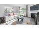 Bright living room with large windows, fireplace, hardwood floors, and open concept to the kitchen at 1748 Post Oak Dr, Haw River, NC 27258