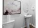 Clean powder room features pedestal sink, oval mirror, and modern abstract art at 1748 Post Oak Dr, Haw River, NC 27258