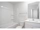 Bathroom with white vanity, toilet, framed mirror, and tub with shower head at 1916 Frost Dr, Haw River, NC 27258