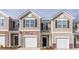 Townhouse with a beige exterior, brick accents, and an attached one car garage at 1916 Frost Dr, Haw River, NC 27258